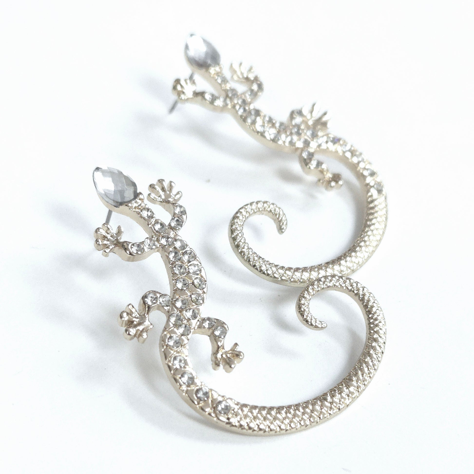 Silver lizard-shaped earrings on a white background