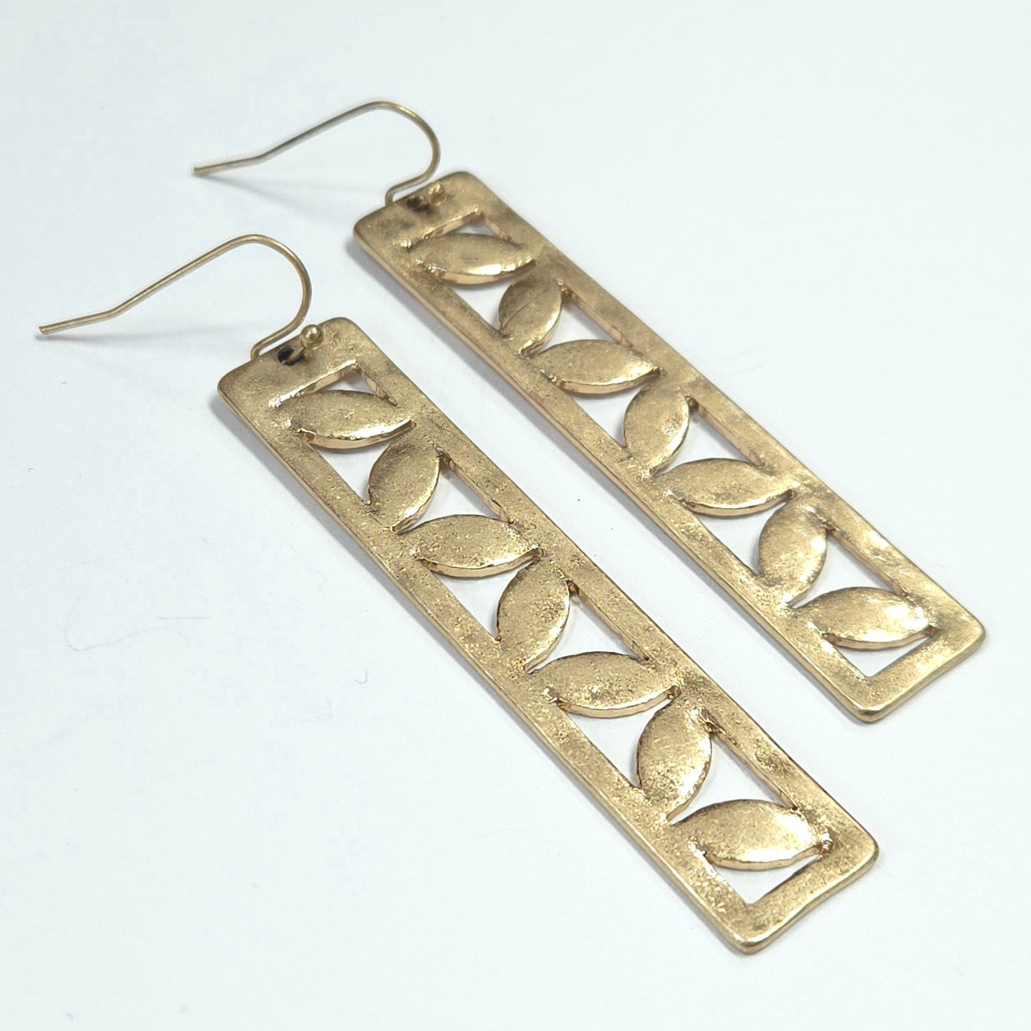 Pair of silver leaf-patterned earrings on a white background