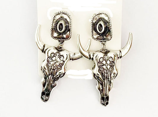 Silver bull head skull earrings on a white background