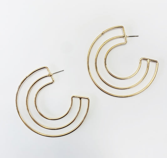 A pair of gold-colored hoop earrings with a geometric retro design, displayed against a white background.