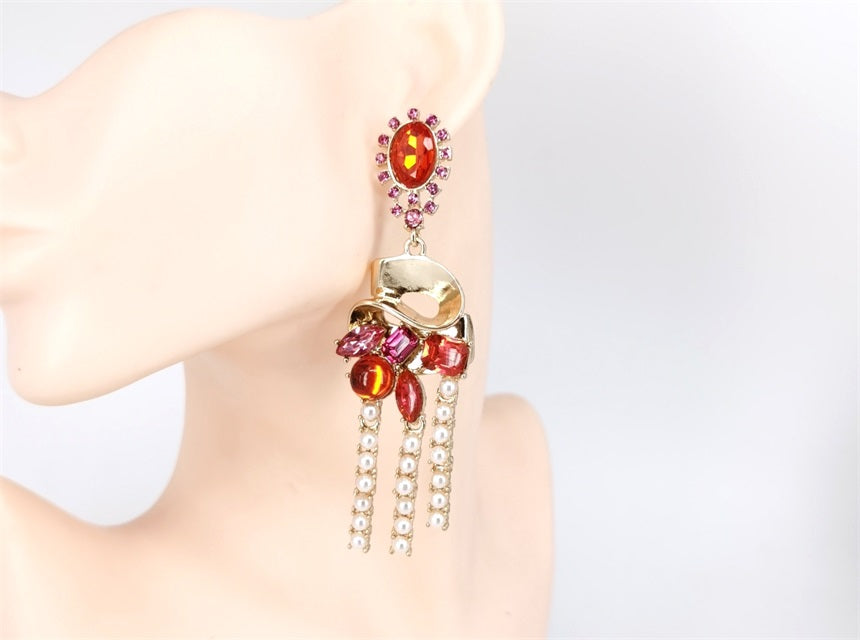 Earring with gemstones on a mannequin ear against a light background