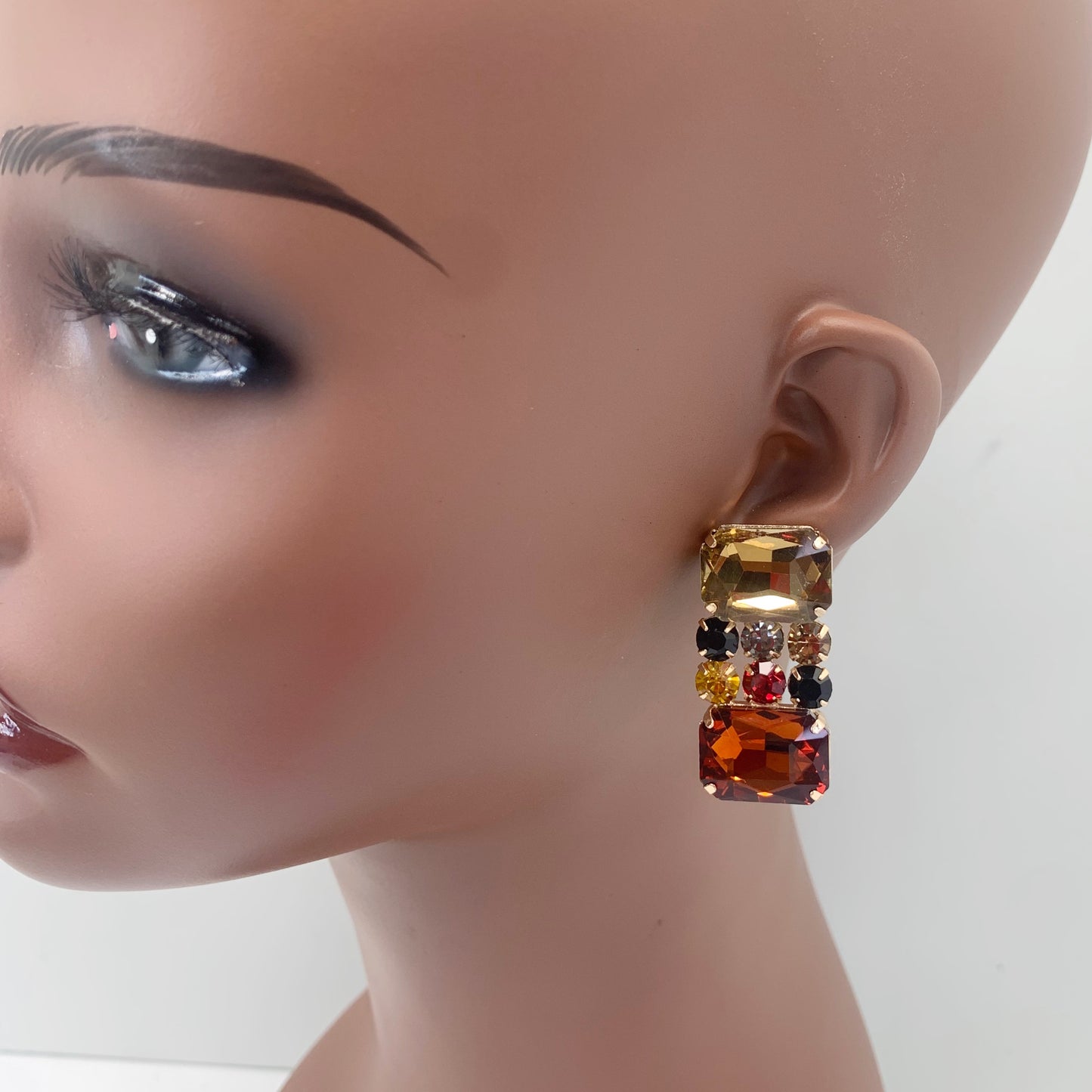 Rectangular crystal drop earrings with multicolor gemstone-inspired accents in a bold glamorous boutique style.