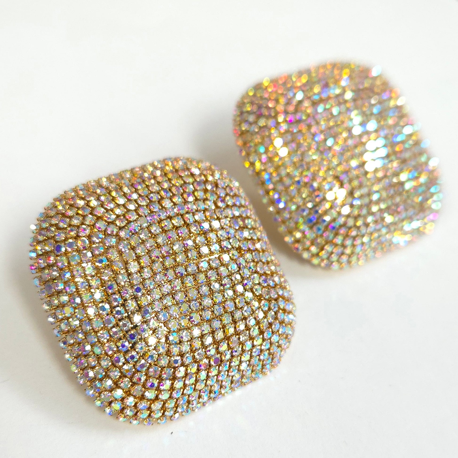 Gold heart-shaped earrings with rhinestone embellishments on a white background
