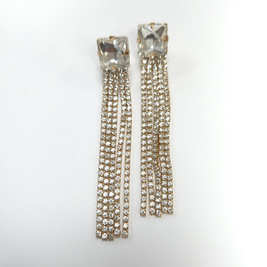 Pair of crystal earrings with dangling chains on a white background