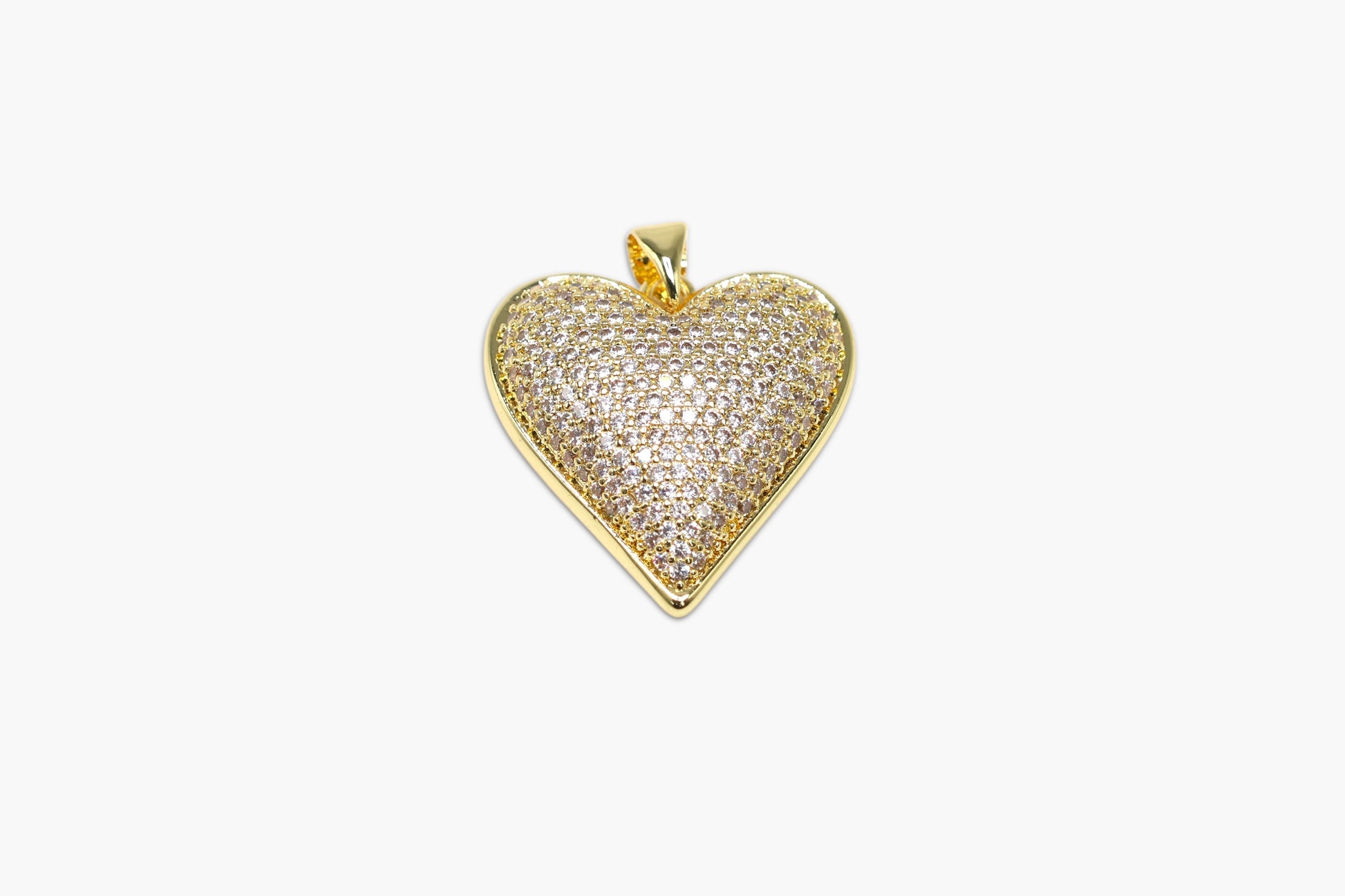 Heart-shaped gold pendant with clear stones on a white background