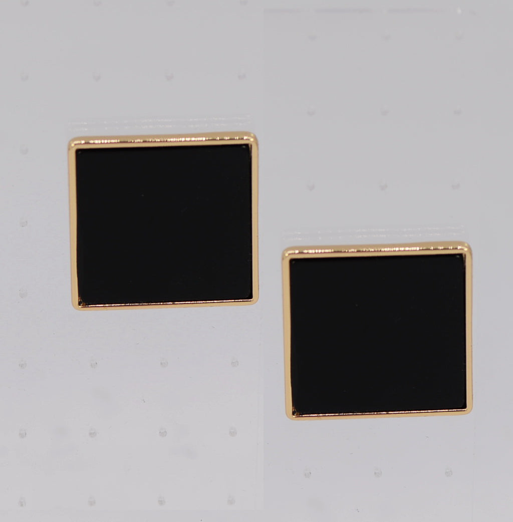 Pair of square black earrings with gold rims on a light gray background