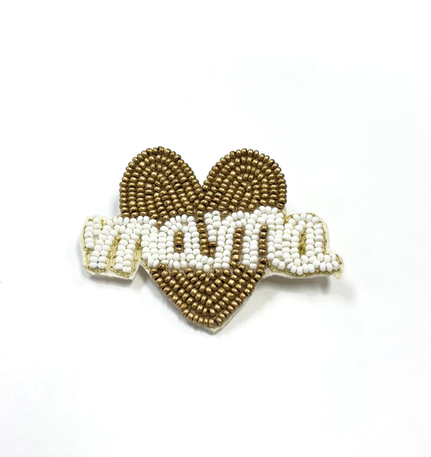 Heart-shaped brooch with 'mama' text in white beads on a gold background