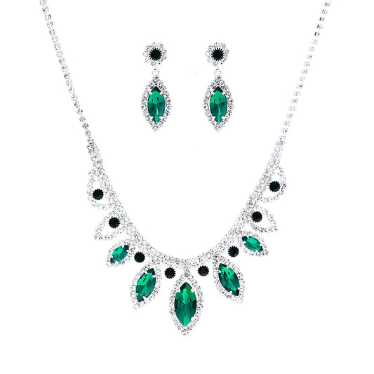 Jewelry set with emerald green gemstones on a white background