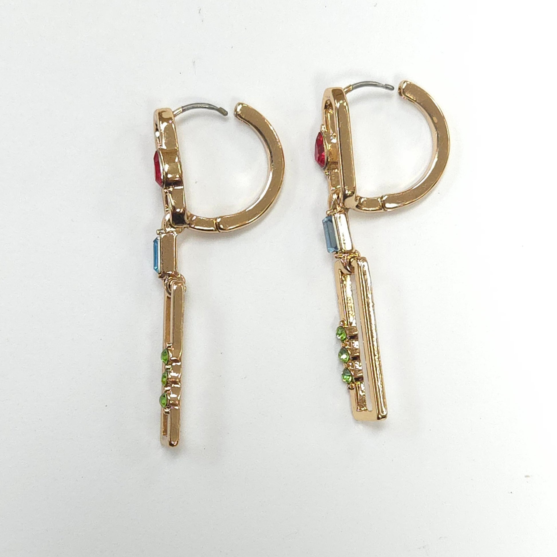 Gold hoop earrings with colorful gemstones on a white background