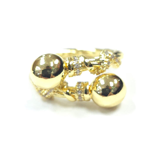 Gold ring with two large spherical stones and smaller stones on a white background