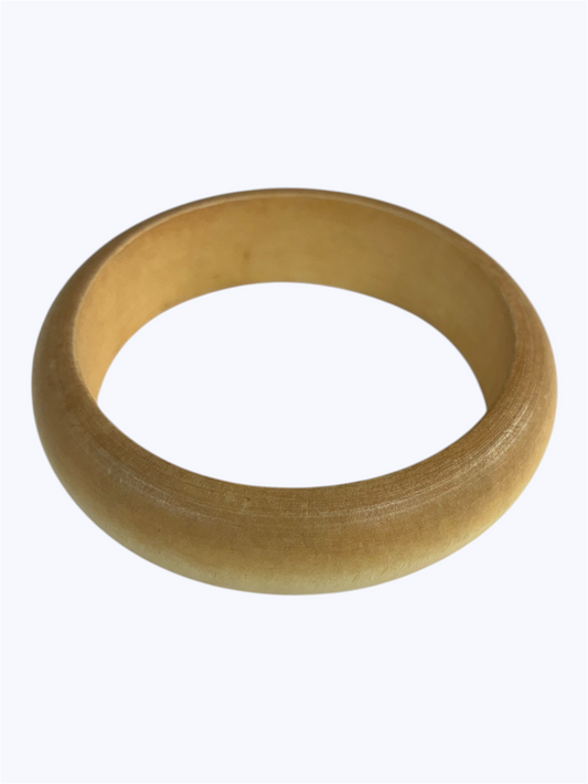 Natural wood bangle bracelet with a smooth rounded silhouette and minimalist artisan style