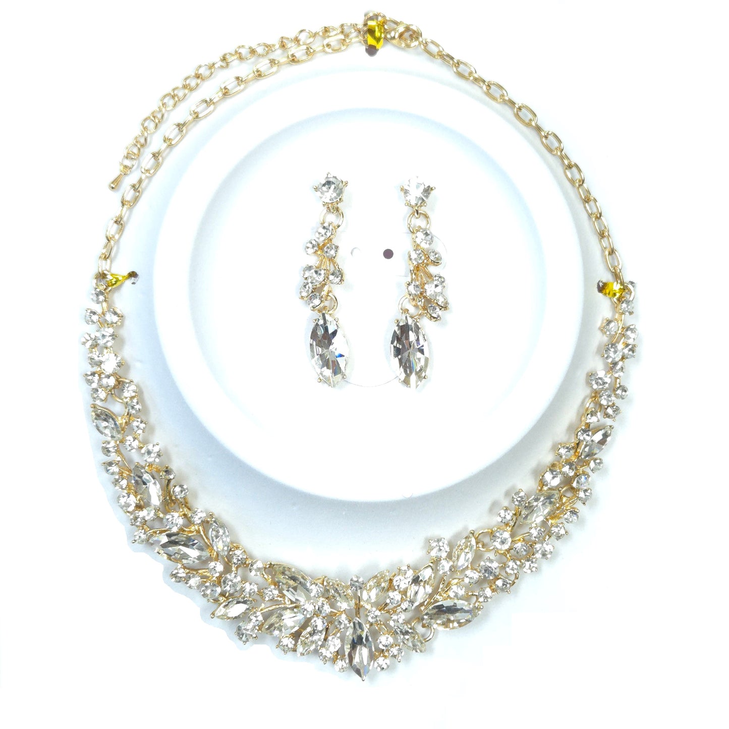 Gold and crystal necklace with matching earrings on a white background