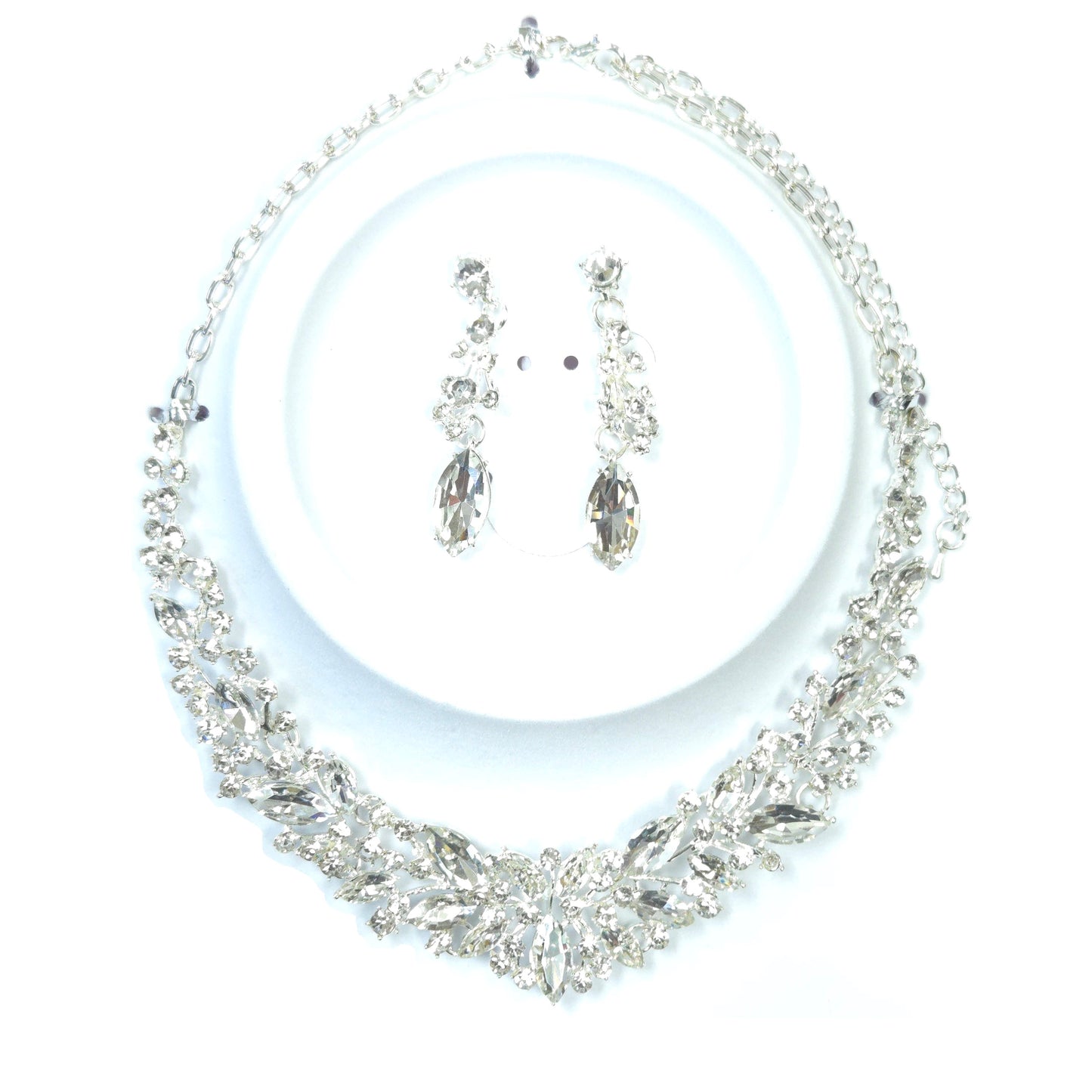 Silver necklace and earrings set on a white background