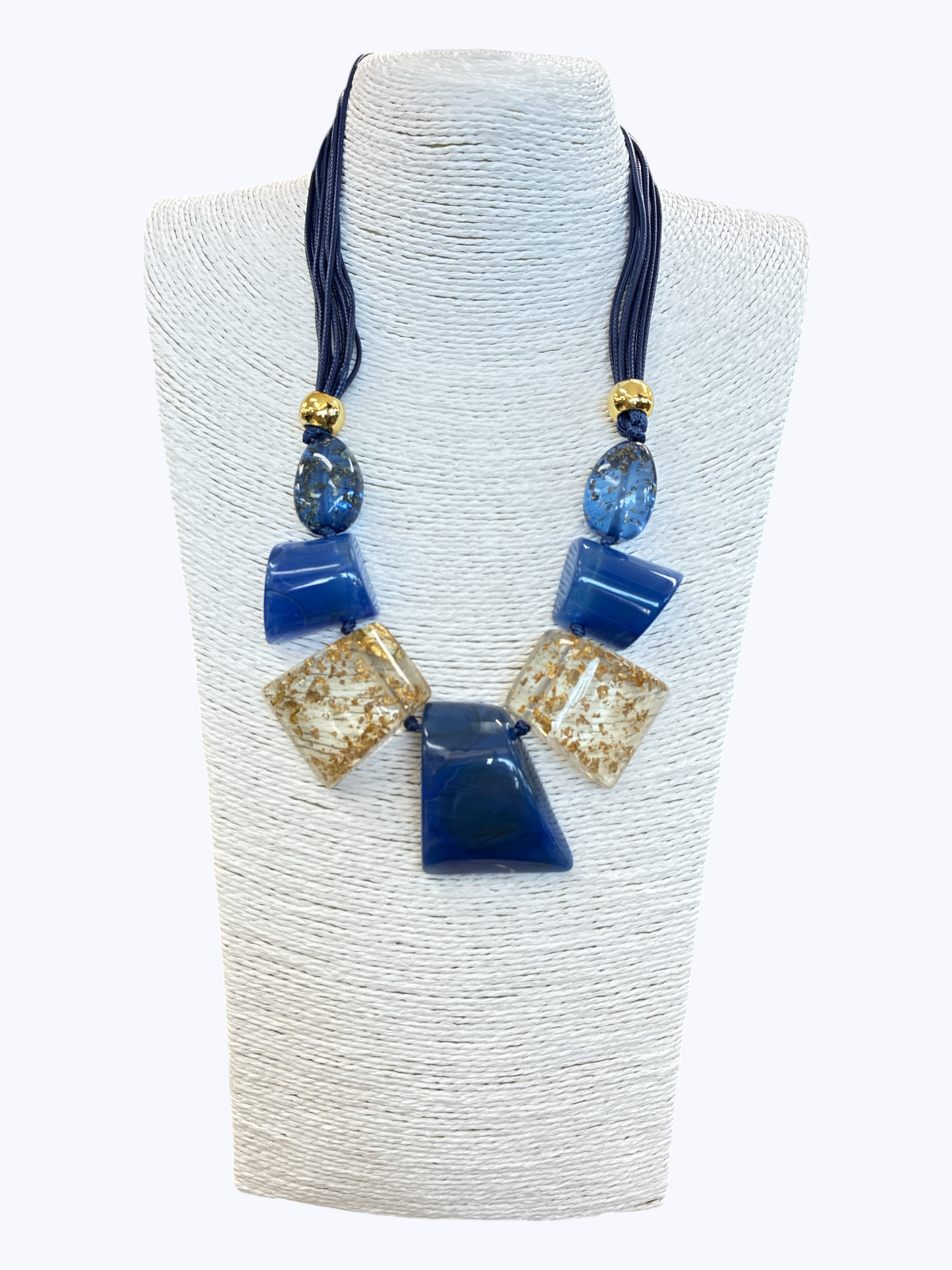 Blue statement necklace with glossy geometric resin accents, gold fleck details, and layered cord strands for a chic modern boutique look.