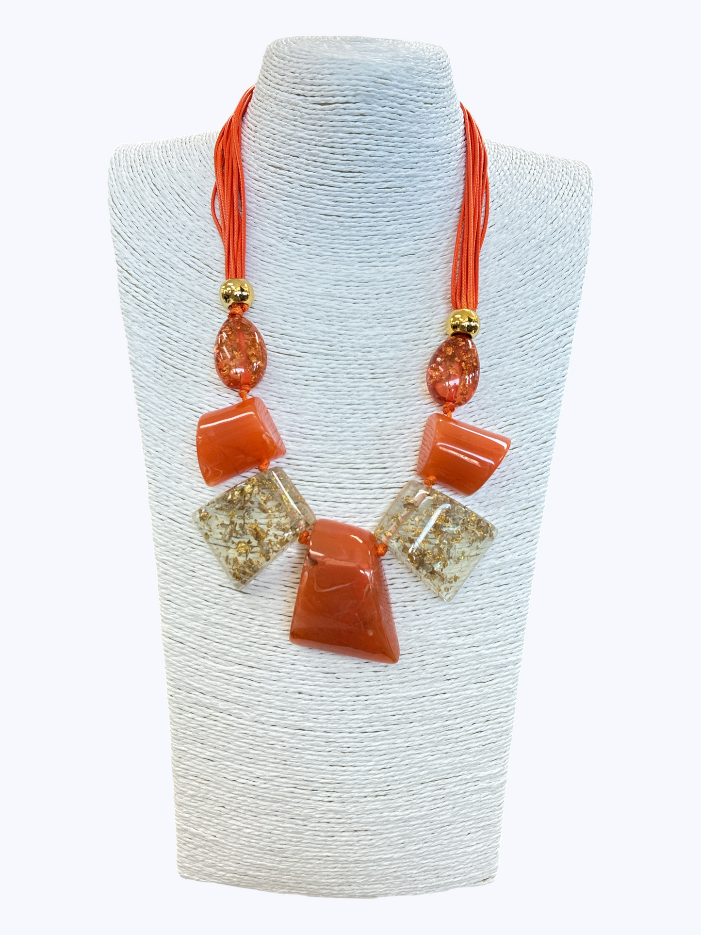 Orange statement necklace with glossy geometric resin accents, gold fleck details, and layered cord strands for a vibrant boutique-inspired style.