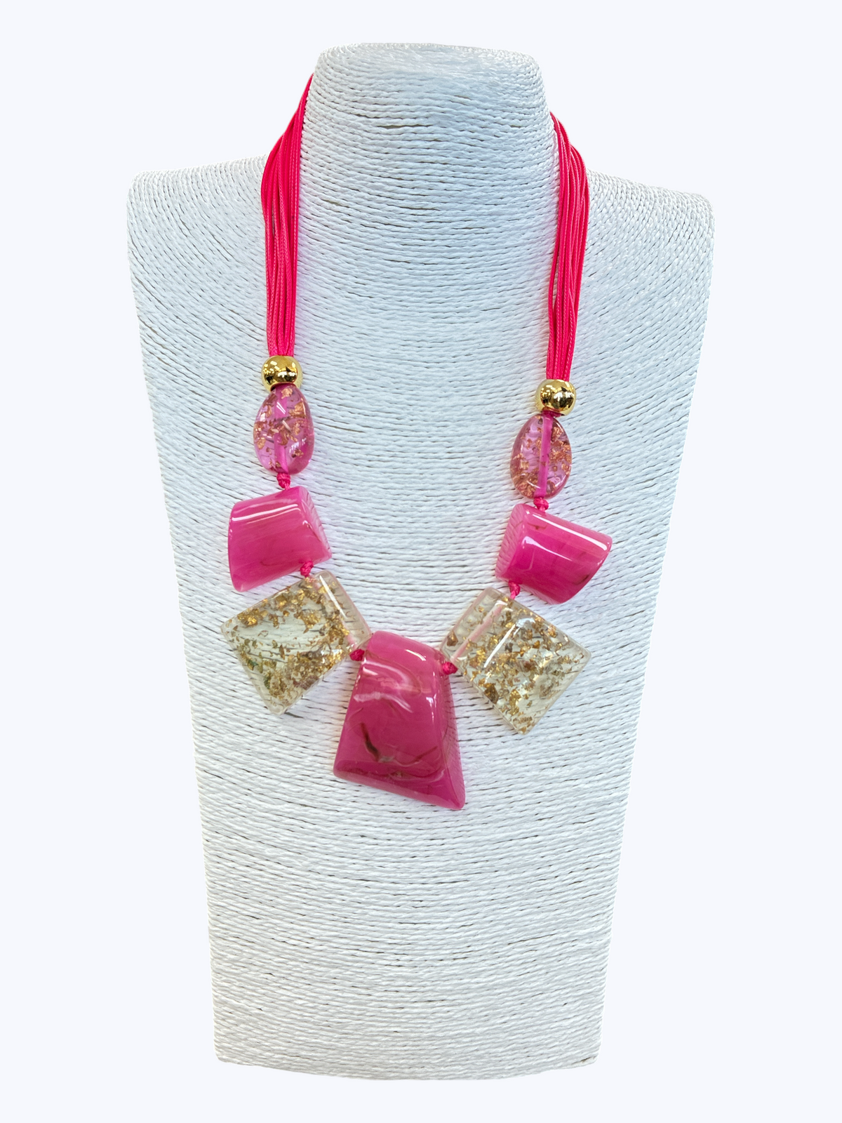 Hot pink statement necklace with glossy geometric resin accents, gold fleck details, and layered cord strands for a playful boutique-inspired style.