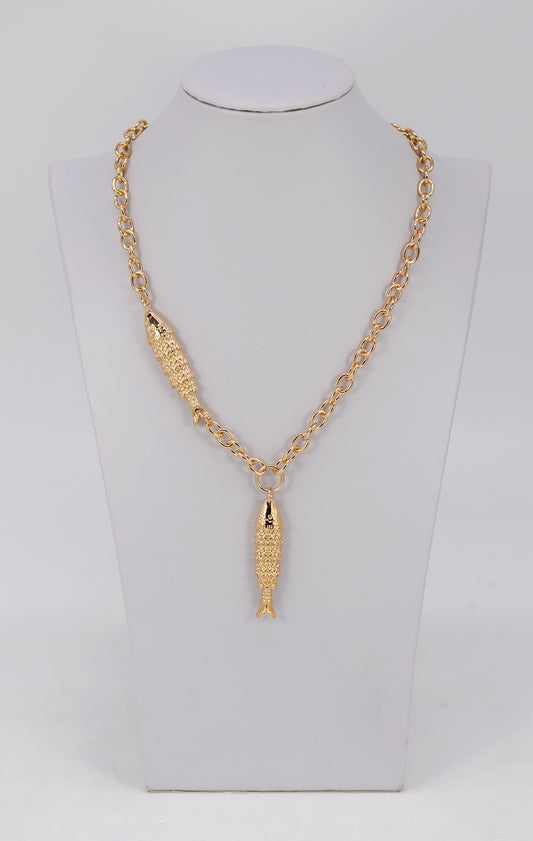 Gold necklace with a fish pendant on a mannequin bust.