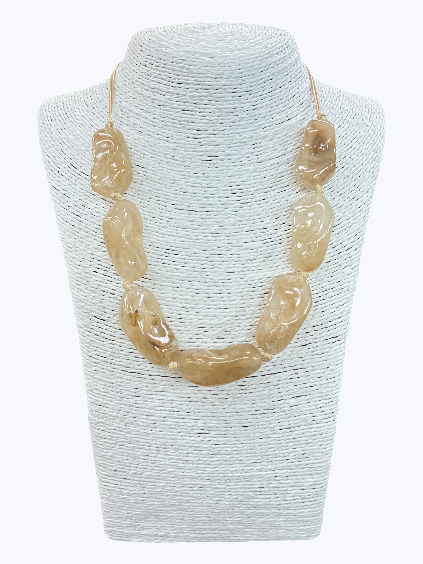 Beige textured bead statement necklace with glossy organic-shaped beads and minimalist cord design on mannequin display