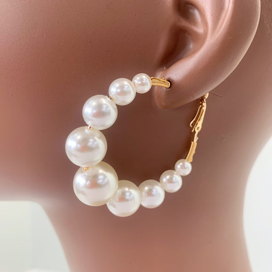 Oversized hoop earrings with graduated faux pearl accents in a glamorous boutique fashion style.