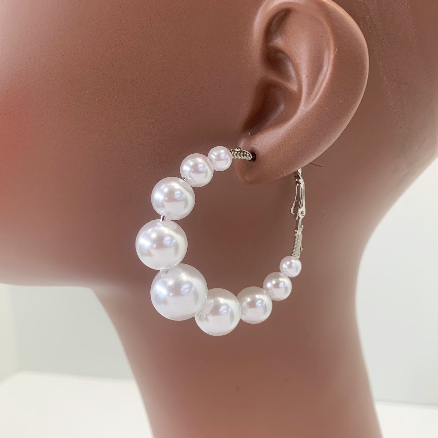 Oversized hoop earrings with graduated faux pearl accents in a glamorous boutique fashion style.