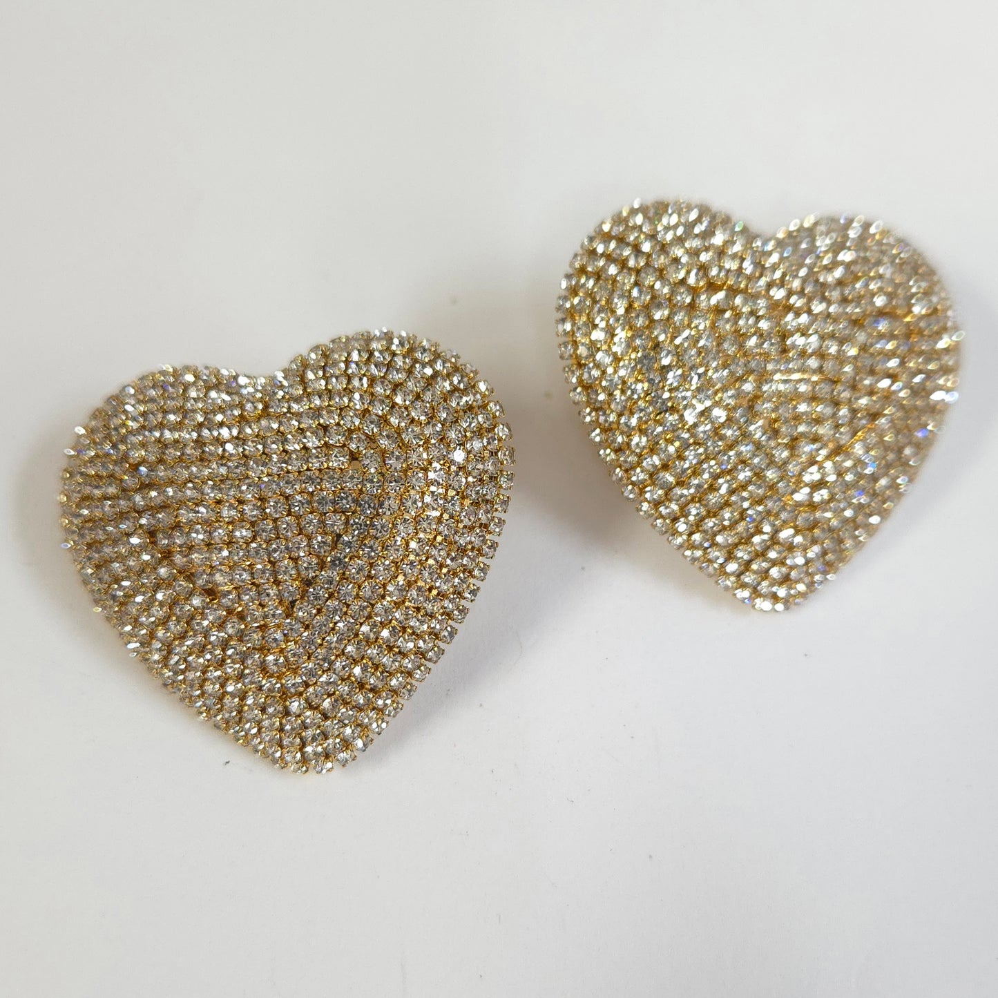 Heart-shaped earrings with a beaded design on a light background