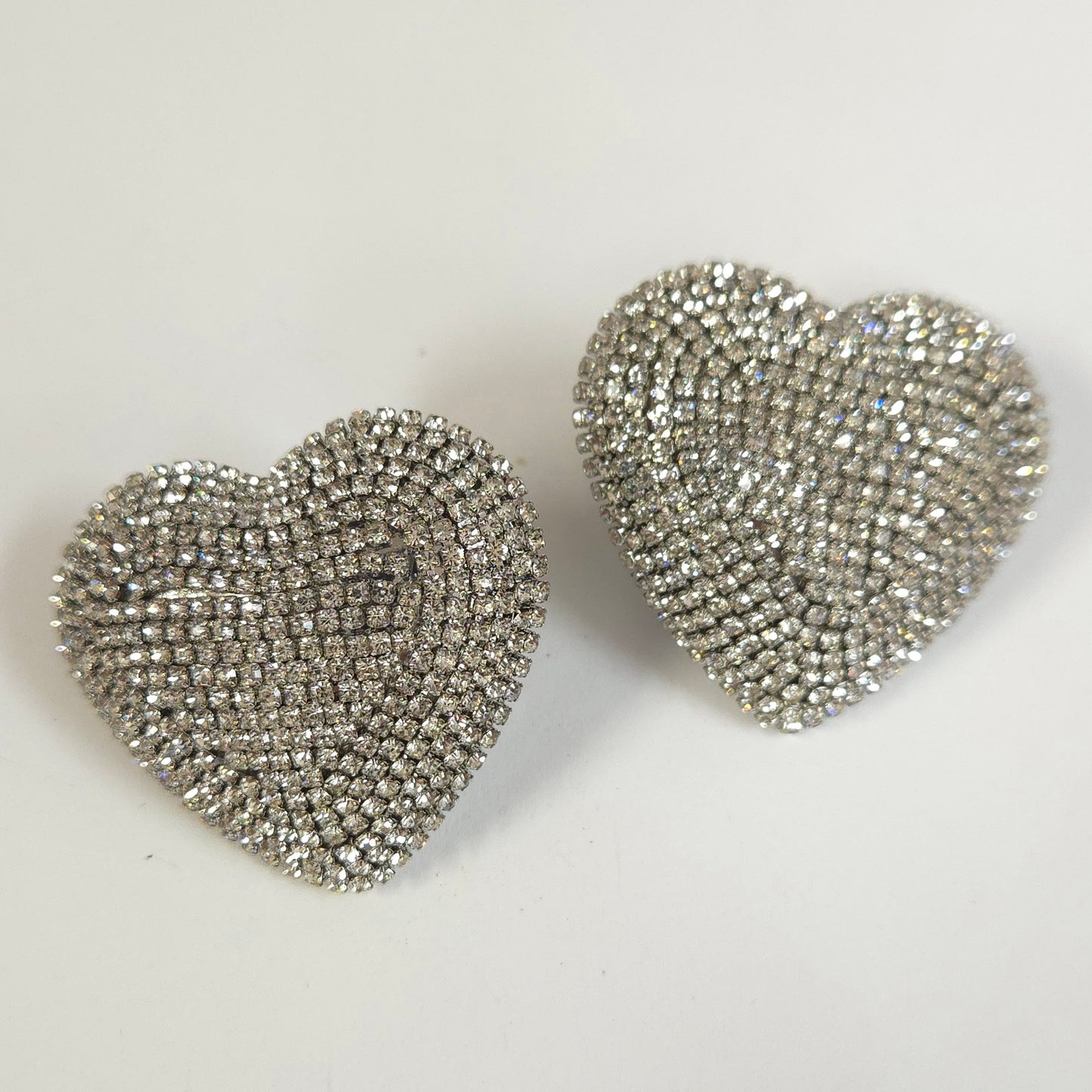 Heart-shaped earrings with rhinestone embellishments on a white background