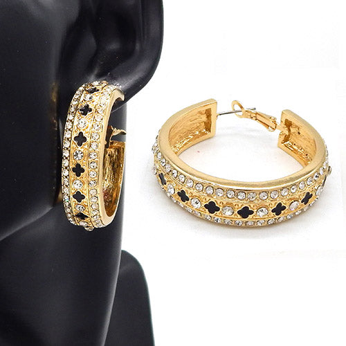Wide hoop earrings with crystal embellishments and cutout motif detailing on a mannequin ear display