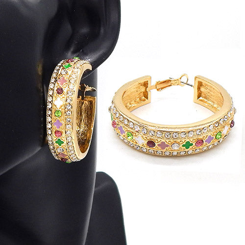 Wide hoop earrings with crystal embellishments and cutout motif detailing on a mannequin ear display