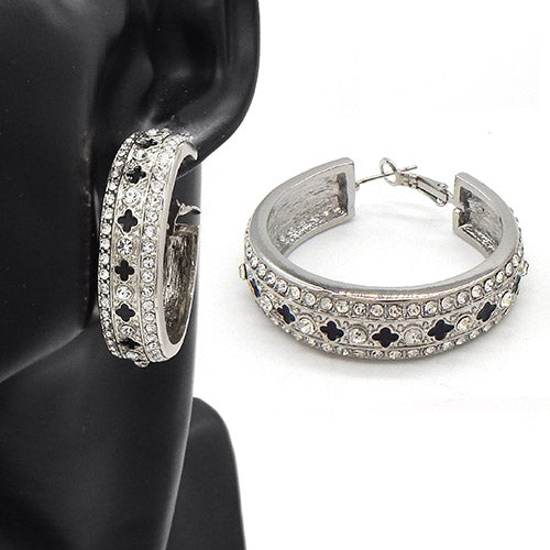 Wide hoop earrings with crystal embellishments and cutout motif detailing on a mannequin ear display
