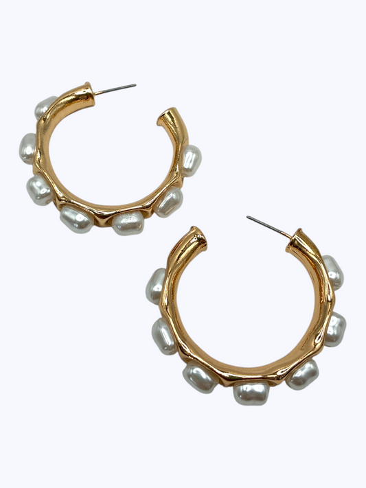 Open hoop earrings with organic textured metal design and pearl accents in a modern boutique style.
