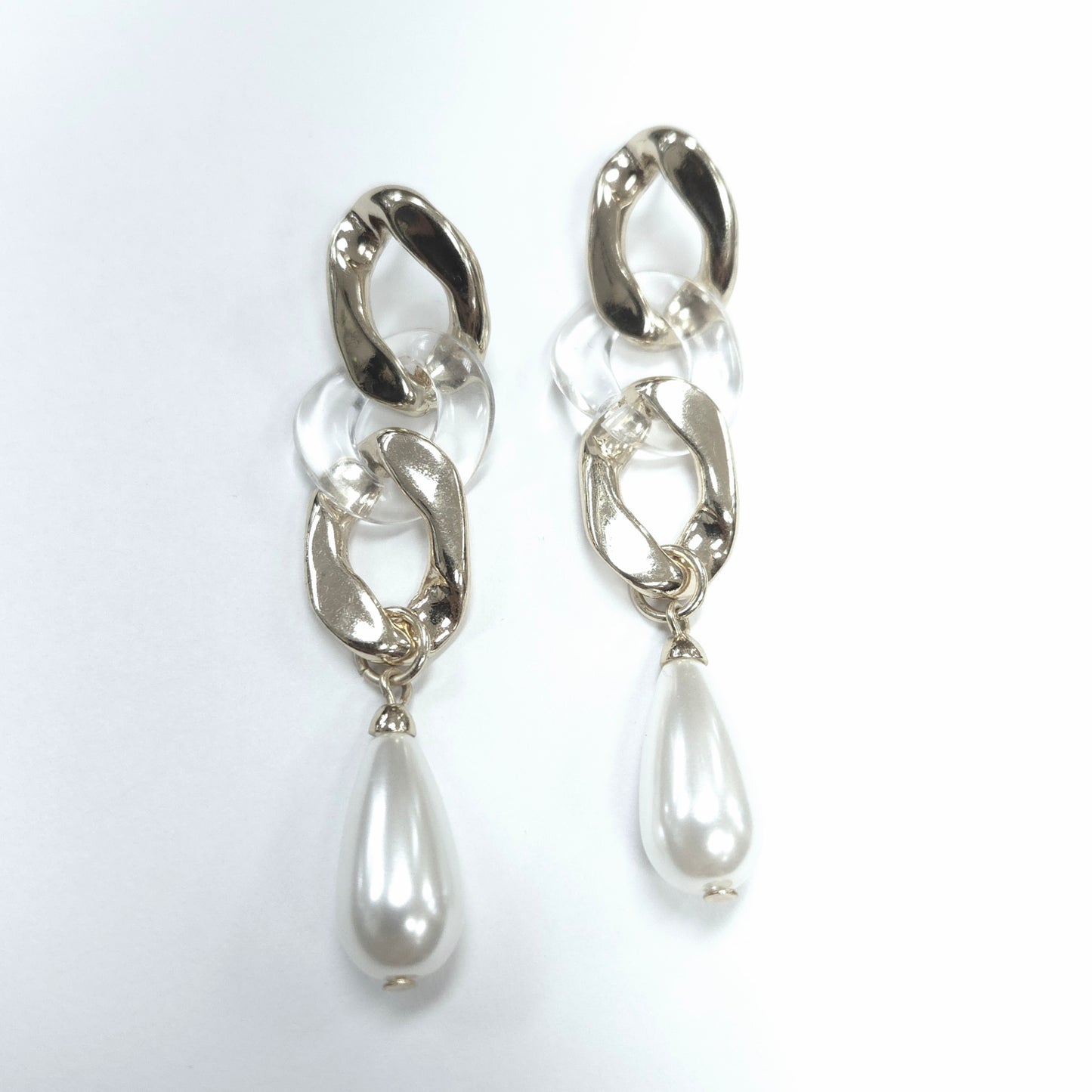 Silver earrings with teardrop-shaped pearls on a white background