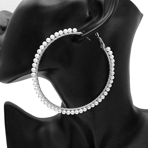 Large hoop earrings with delicate pearl trim detailing along the outer edge on a mannequin ear display