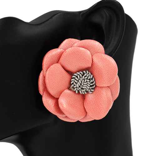 Pink flower-shaped brooch on a black background