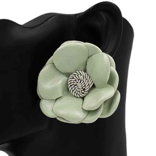 Green flower-shaped brooch on a black background