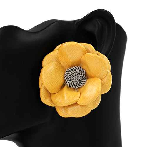 Yellow flower-shaped brooch on a black background