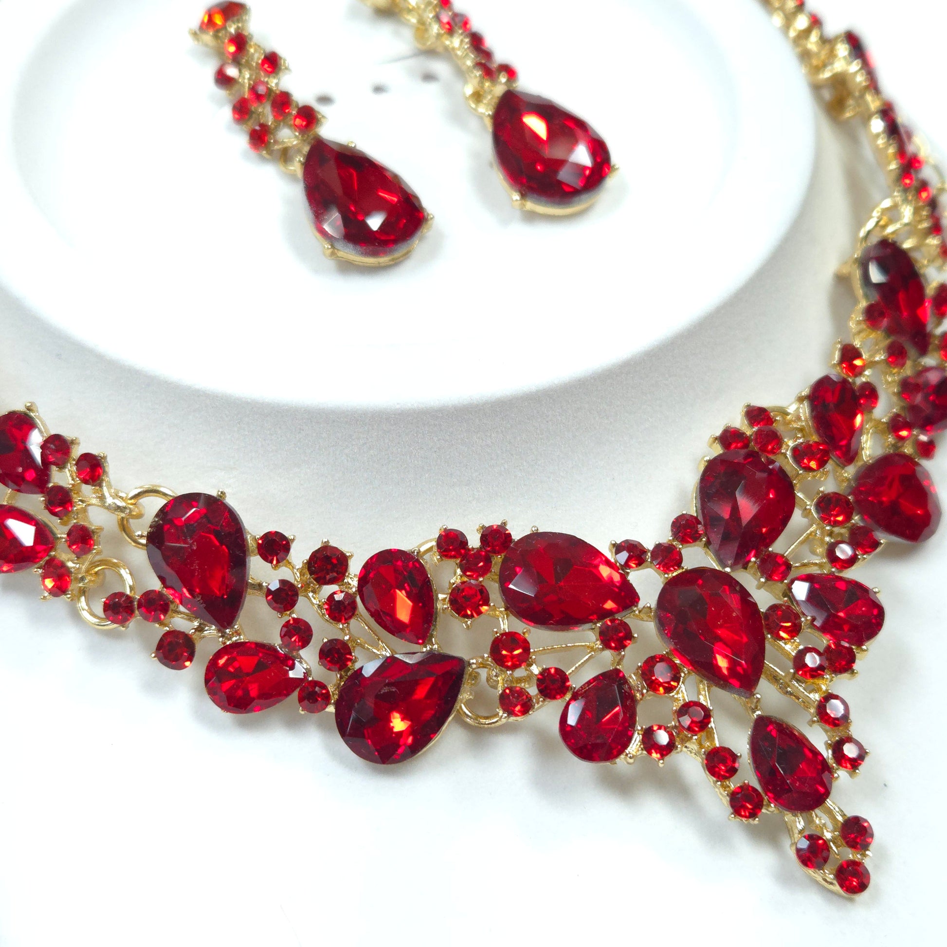 Red gemstone necklace with gold accents on a white background