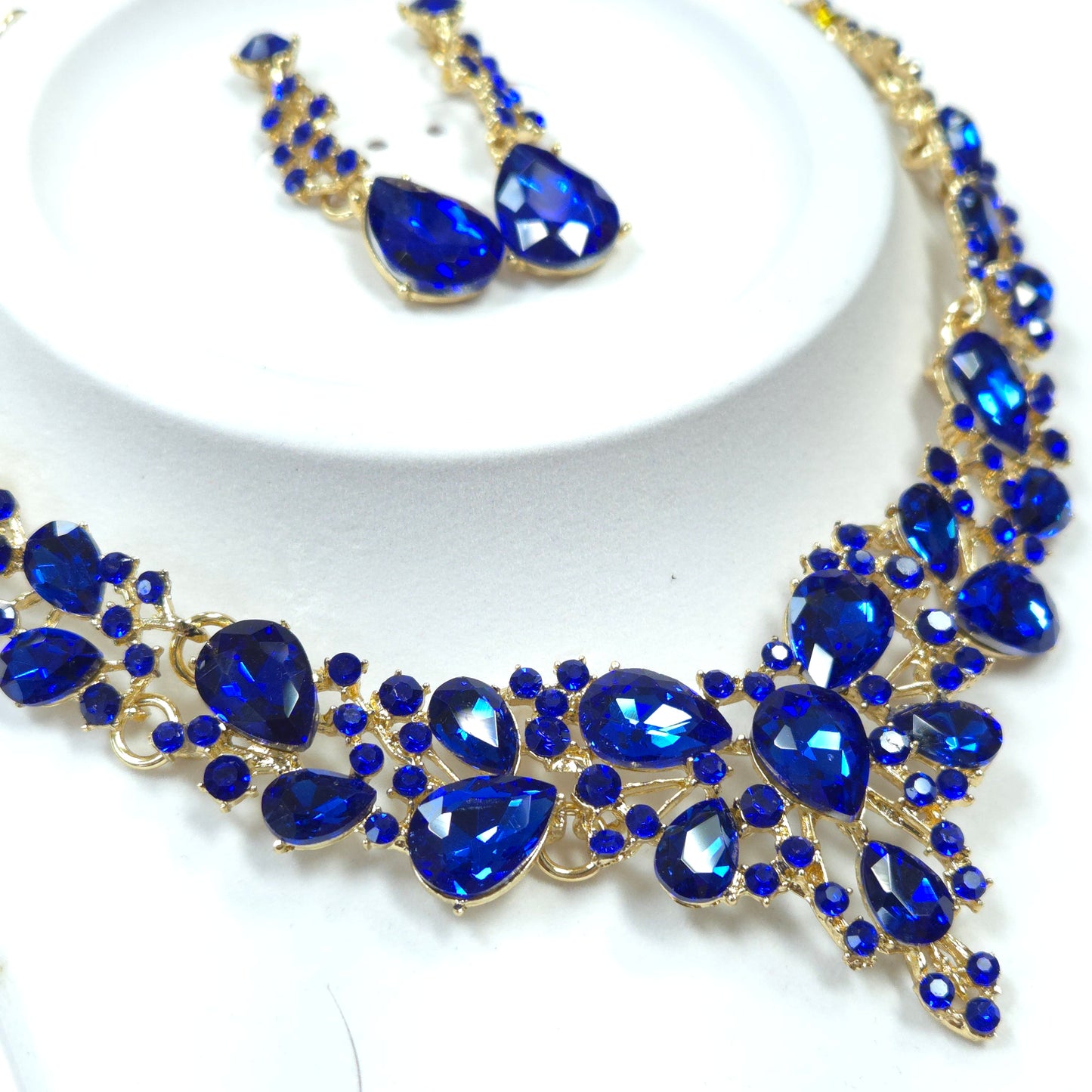 Jewelry set with blue gemstones and gold accents on a white background