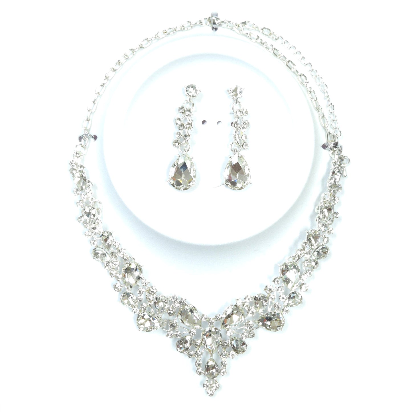 Silver necklace and earrings set on a white background