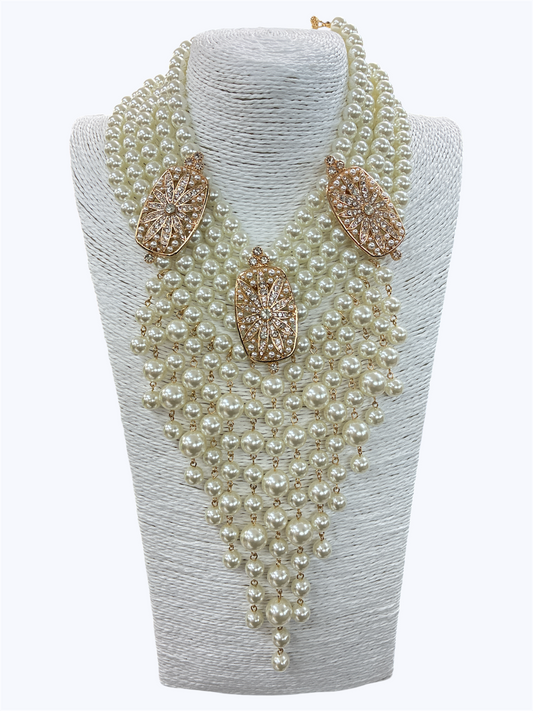 Layered faux pearl statement necklace featuring cascading pearl fringe strands with rhinestone geometric accents and dramatic bib styling.