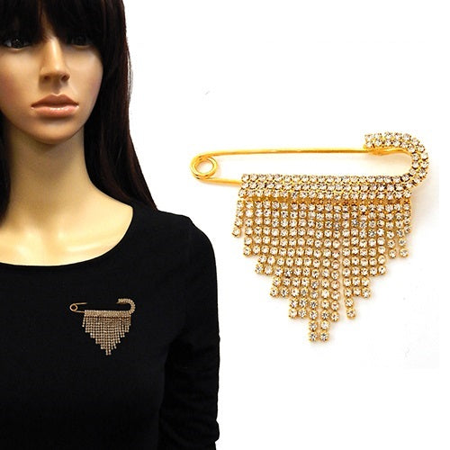 Gold brooch with rhinestone details on a mannequin and plain background