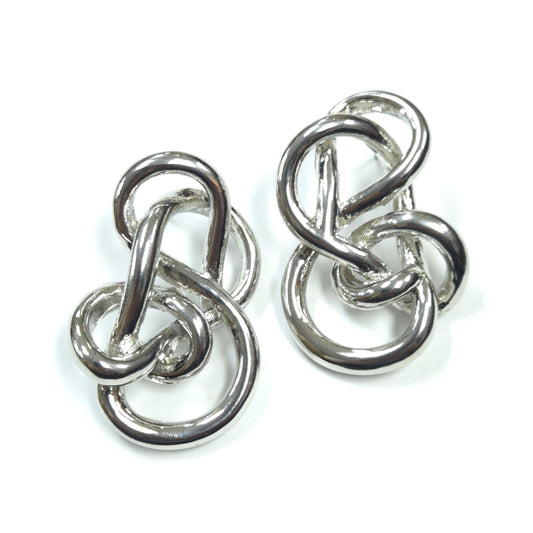 Pair of silver knot earrings on a white background