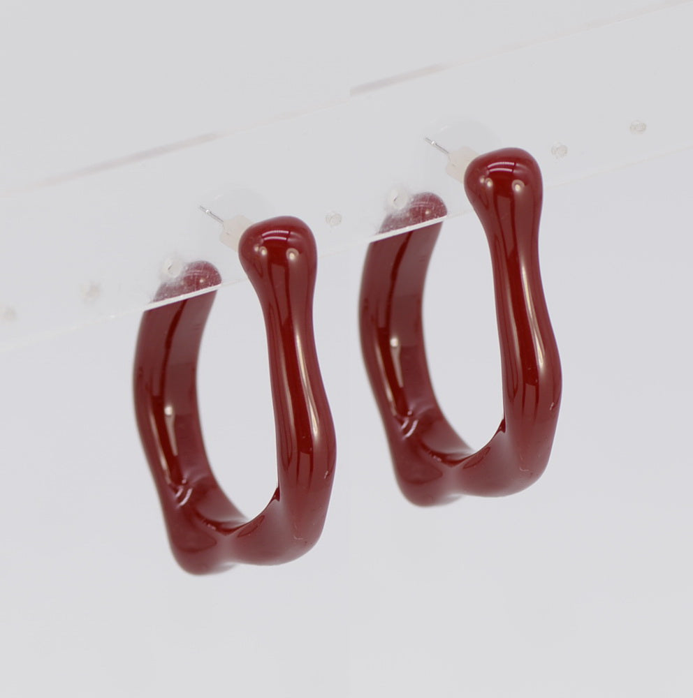 Pair of red hoop earrings on a white background