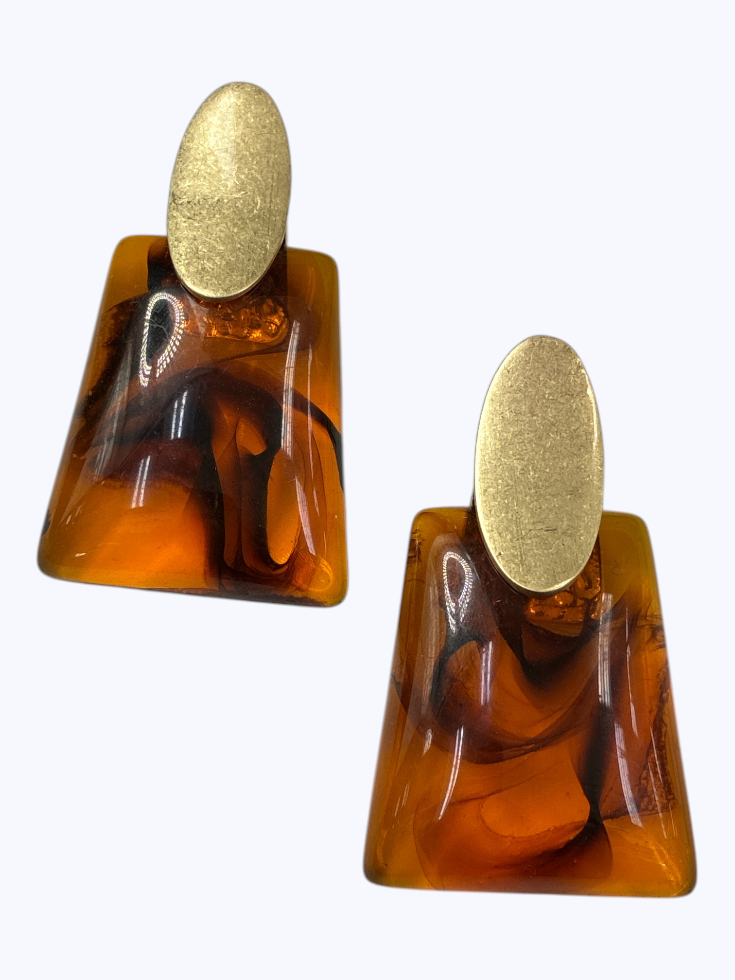 Amber tortoiseshell resin drop earrings with geometric trapeze shapes and brushed gold oval studs in a retro-inspired statement style