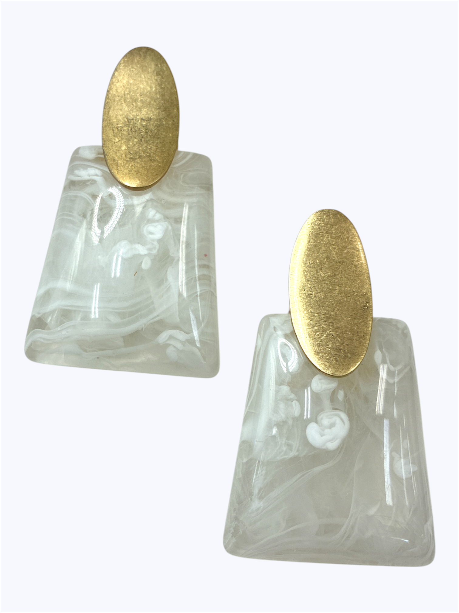 Marbled white resin drop earrings with geometric trapeze shapes and brushed gold oval studs in a modern minimalist style