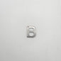 Silver letter 'B' charm on a light gray background