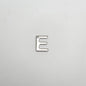 Silver letter 'E' charm on a light gray background