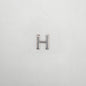 Silver letter 'H' charm on a white background