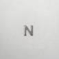 Silver letter 'N' charm on a light gray background