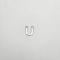 Silver U-shaped object on a light gray background