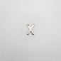 Silver 'X' charm on a light gray background